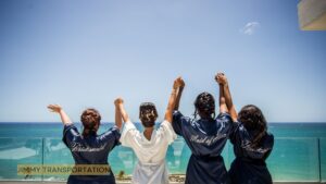 Bride and bridesmaids posing on a sunny hotel balcony overlooking Nassau’s tropical ocean before a bachelor or bachelorette party.