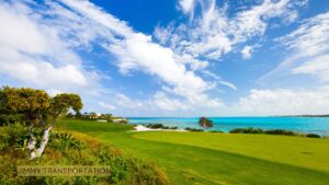 Tropical golf course overlooking a turquoise ocean with palm trees and clear blue skies